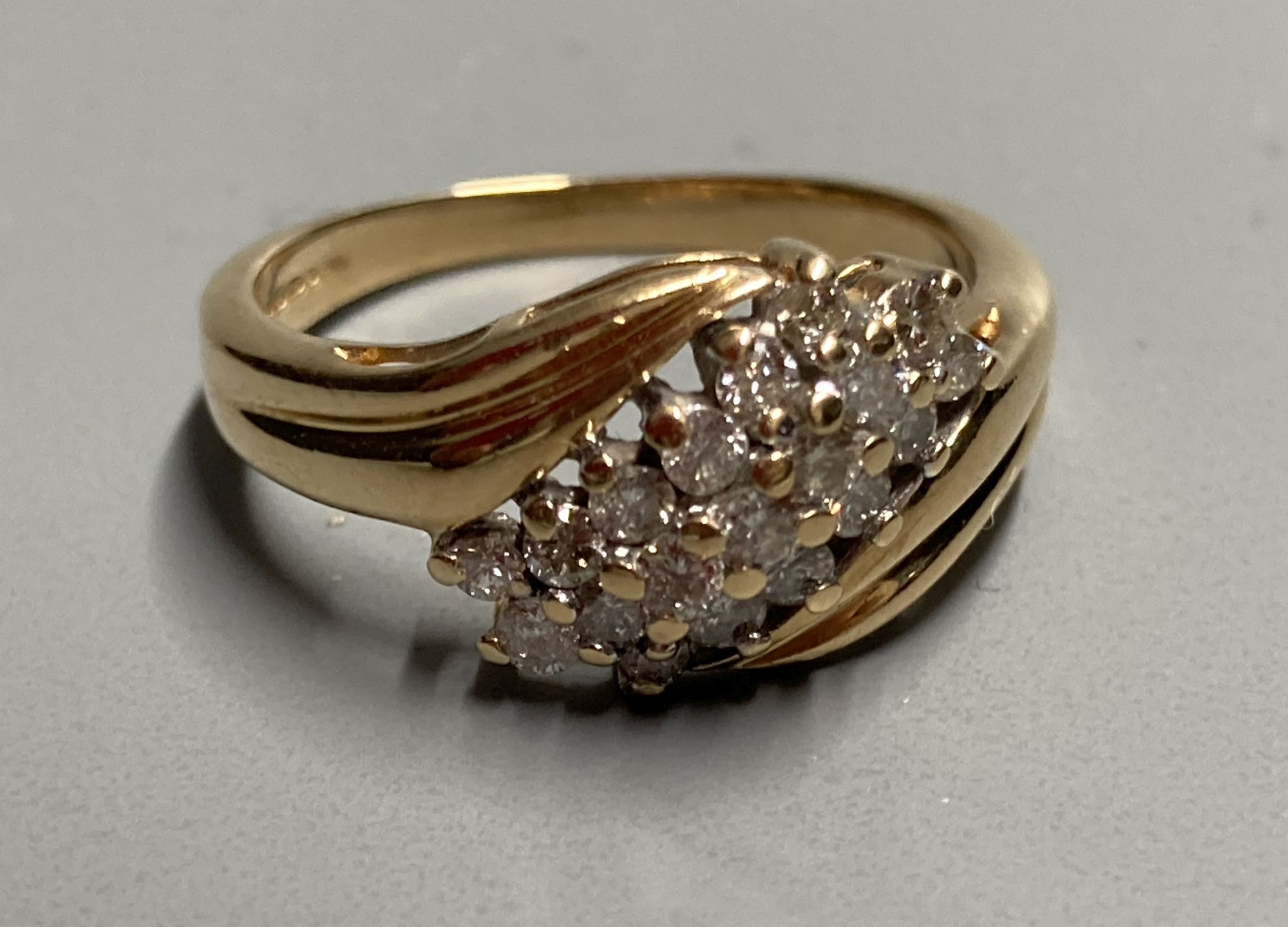 A modern 18ct gold and nineteen stone three stone three row diamond crossover ring, size N, gross 4.3 grams.